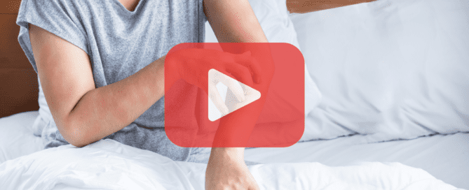 A woman scratching her red, irritated arm while sitting on a bed with white sheets, suggesting a reaction to bed bug bites. The Prevent Pest Control logo and a play button overlay are visible.